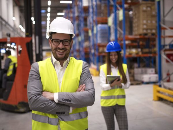 portrait-of-successful-warehouse-worker-or-supervisor-with-crossed-arms-standing-in-large-storage-distribution-area-min-scaled.jpg